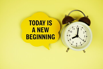 Today is a New Beginning text on speech bubble with alarm clock on yellow background