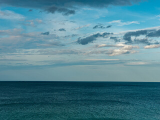 Obraz premium The view of the calm blue sea with beautiful clouds
