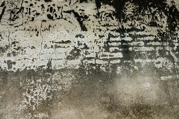 A wall with a lot of cracks and dirt on it. The wall is old and has a lot of wear and tear