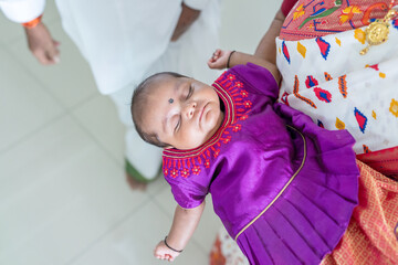 Obraz premium ndian family spending time together, wearing traditional and casual outfits with a baby, a young girl, and grandparents in a high-rise apartment in Kuala Lumpur, Malaysia.