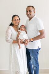 ndian family spending time together, wearing traditional and casual outfits with a baby, a young girl, and grandparents in a high-rise apartment in Kuala Lumpur, Malaysia.