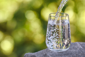 drinking water pouring into glass on stone
