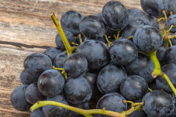 grappe de raisins noirs, en gros plan, sur une table en bois