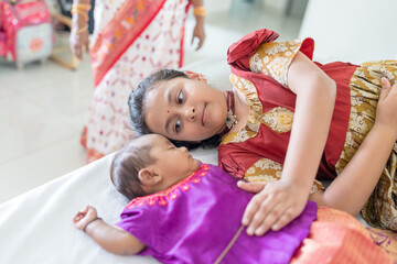 ndian family spending time together, wearing traditional and casual outfits with a baby, a young girl, and grandparents in a high-rise apartment in Kuala Lumpur, Malaysia.