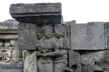 Stone relief wall depicting Buddha and female characters at the ancient historical Buddhist UNESCO...