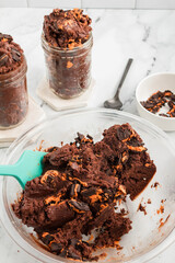 Bowl of non-bake brownie batter mixed with Halloween cookies