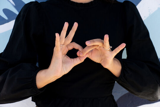 Closeup of hands signing 'connect' in ASL