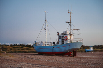 Obraz premium Fishing boats on Slettestrand Beach, Denmark, at sunset by the sea