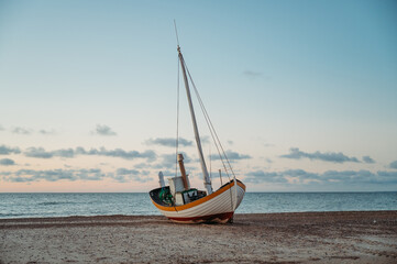 Fishing boat on Slettestrand Beach, Denmark, at sunset by the sea