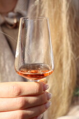 An Elegant Glass Being Held in a Hand, Surrounded by Warm Tones and a Soft Background