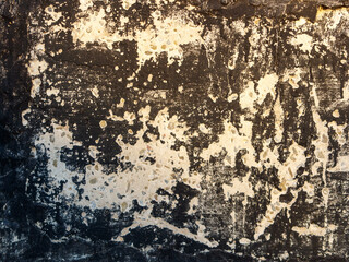 A black and white photo of a wall with white paint peeling off