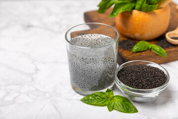 Basil seeds on textured wooden background. Close-up. Superfood. Ocimum basilicum. Organic basil seeds. selasih. Space for text. Copy space.