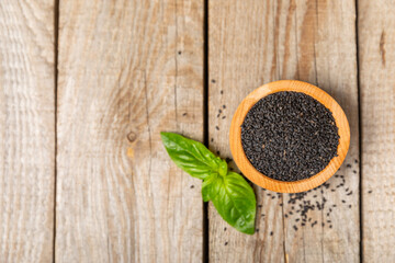 Basil seeds on textured wooden background. Close-up. Superfood. Ocimum basilicum. Organic basil seeds. selasih. Space for text. Copy space.