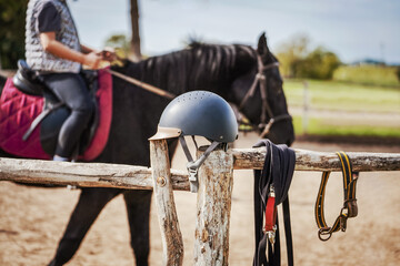 Horse riding helmet on the old wooden fence. Sport and recreation concept