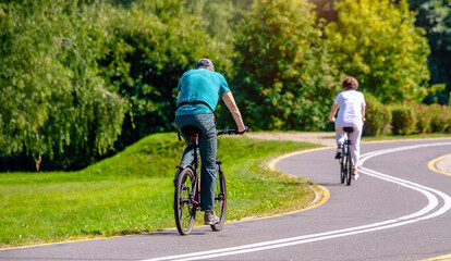 Naklejka premium Cyclists ride on the bike path in the city Park 
