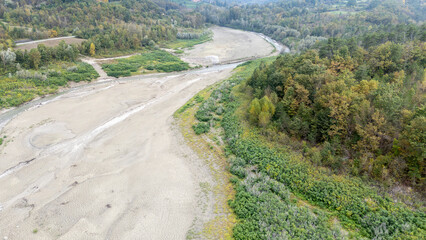 Almost dry riverbed running through autumn landscape