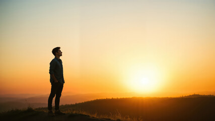 Fototapeta premium Contemplative Man Enjoying Scenic Mountain Sunset View