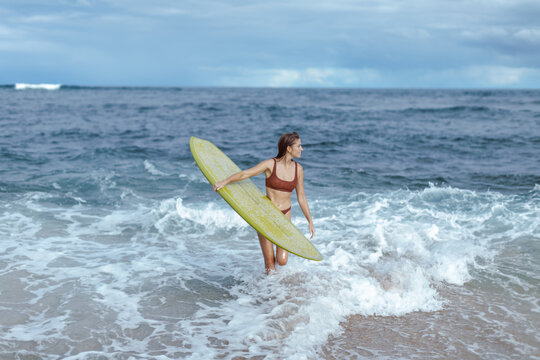 Woman surfer exiting the ocean
