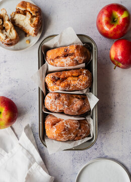 Top view close up of baked apple fritters on light backdrop.