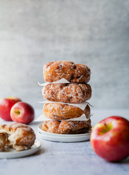 Close up of stack of baked apple fritters on light background.