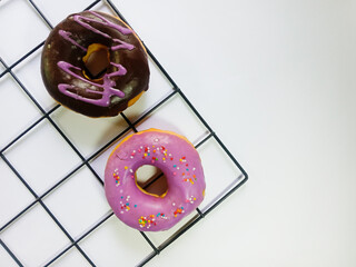 donut with sprinkles. two donuts isolated on a white background. chocolate donuts with purple cream...