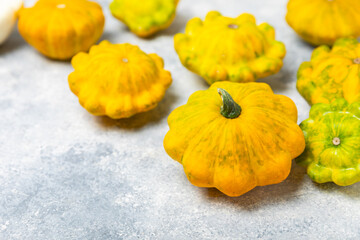 Pattypan zucchini on a textured kitchen table. squash. Fresh organic pattypan squashes on...