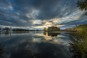 A lake with a cloudy sky in the background