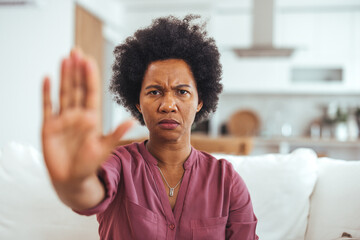 Confident Woman Making a Stop Gesture in Cozy Living Room