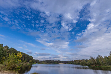 A calm lake with a blue sky in the background