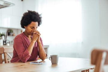 Stressed Woman Reflecting at Home With Hands Clasped