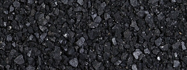 A close-up view of black gravel or asphalt, showcasing its texture and color.