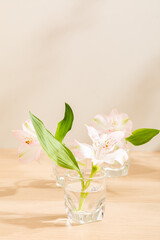 Beautiful Alstroemeria in warm lighting background. White and wooden surface. Light and Shadow wallpaper. Space for text. Backdrop. Studio photography. Cozy wallpaper. Empty space. Blossom Flower.