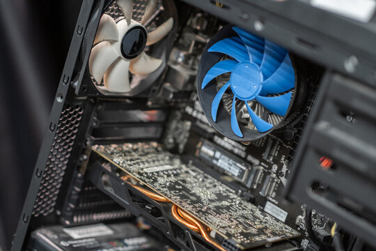 Inside a computer case showcasing components like a graphics card, cooling fan, and intricate circuitry during home assembly
