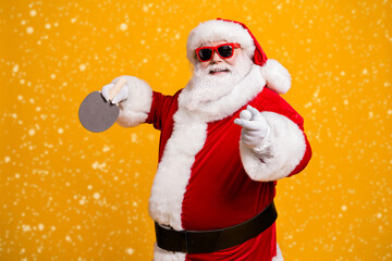 Profile side view portrait of his he nice attractive cheerful cheery fat overweight Santa enjoying playing table tennis contest workout isolated bright vivid shine vibrant yellow color background