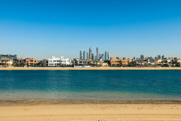 Naklejka premium Scenic view of Dubai beachfront highlighting modern architecture and calm waters on a bright sunny day