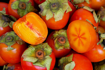 Many orange persimmon fruits as background