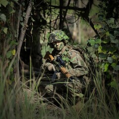 Stealth Soldier in Full Camouflage on a Tactical Mission in the Forest