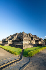 Borobudur, Mahayana Buddhist Temple in Indonesia - Mageland, Yogyakarta. Wide Angle of ancient stupa pyramid from north-west corner.