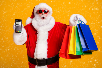 Portrait of his he nice attractive amazed astonished fat Santa holding in hands things digital...