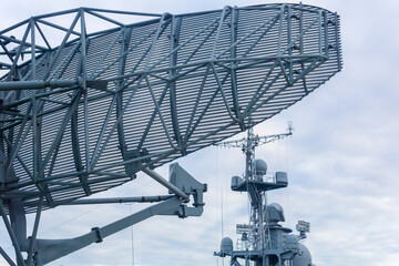 military background, naval radar antenna close up and warship in the background