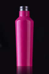 Pink reusable water bottle on black background with reflection