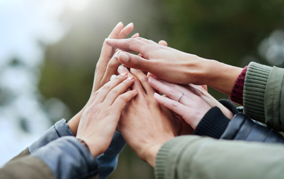 People, group and hands together with community for unity, motivation or mission in nature. Closeup, huddle or team piling or touching for collaboration, coordination or solidarity at outdoor park