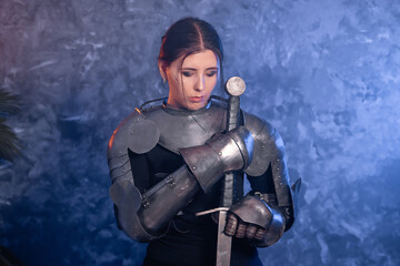 Portrait of a young woman with scars on her face, dressed in black clothes with steel knightly...