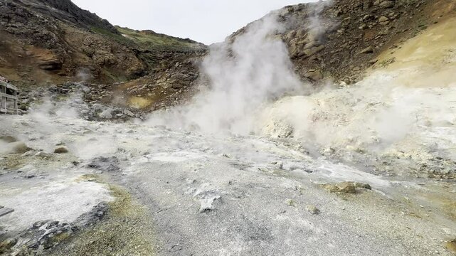 steam blowing from fumaroles in the ground in a geothermal area