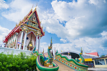 Fototapeta premium Lop Buri, Thailand - September, 20, 2024 :Majestic Thai Temple with Serpent Naga Sculptures under a Bright Blue Sky at Lop Buri, Thailand.