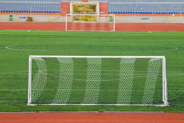 STADIUM - Football field with goal and tablo on blue sky