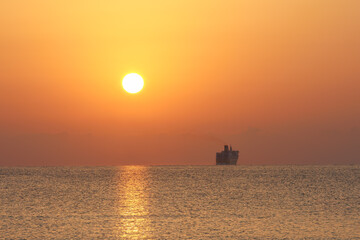 Sunrise with ferry and large sun over the sea at Mallorca