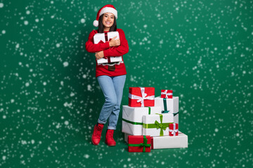 Full length photo of dreamy charming girl dressed ugly print red x-mas pullover hugging presents stack pile isolated green color background