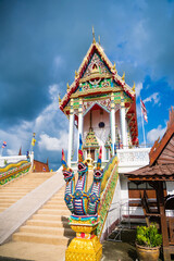 Lop Buri, Thailand - September, 20, 2024 :Majestic Thai Temple with Serpent Naga Sculptures under a Bright Blue Sky at Lop Buri, Thailand.