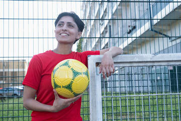 United Kingdom, Portrait of female football player posing with ball